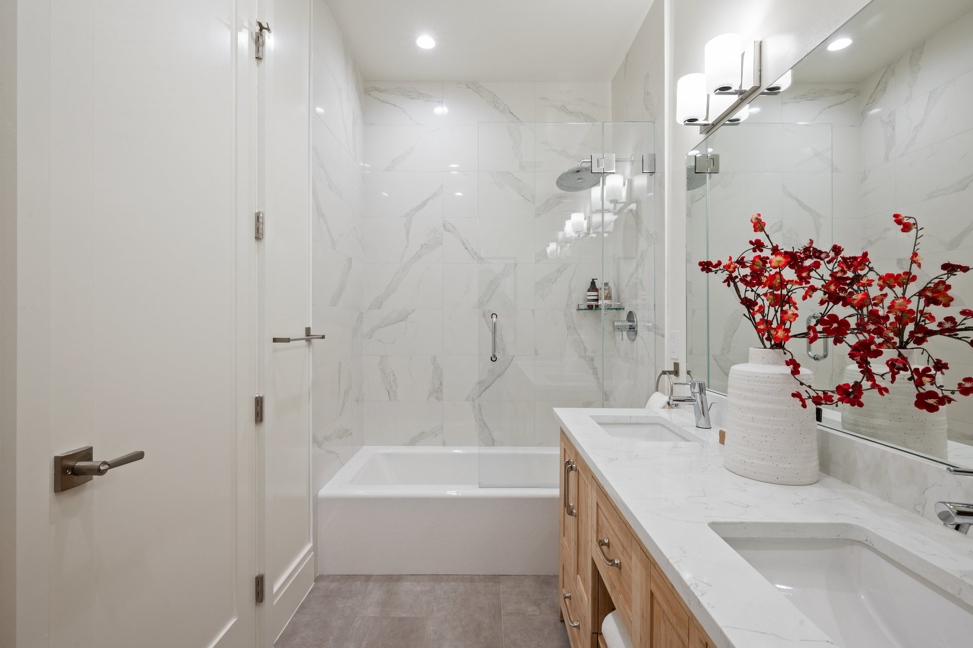 Property Photo: Primary bathroom. White walls, bath tiles and double vanity. 