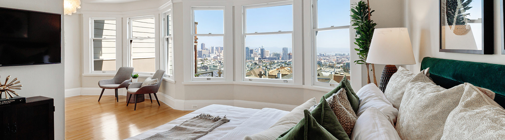A bed room with a view of the San Francisco skyline