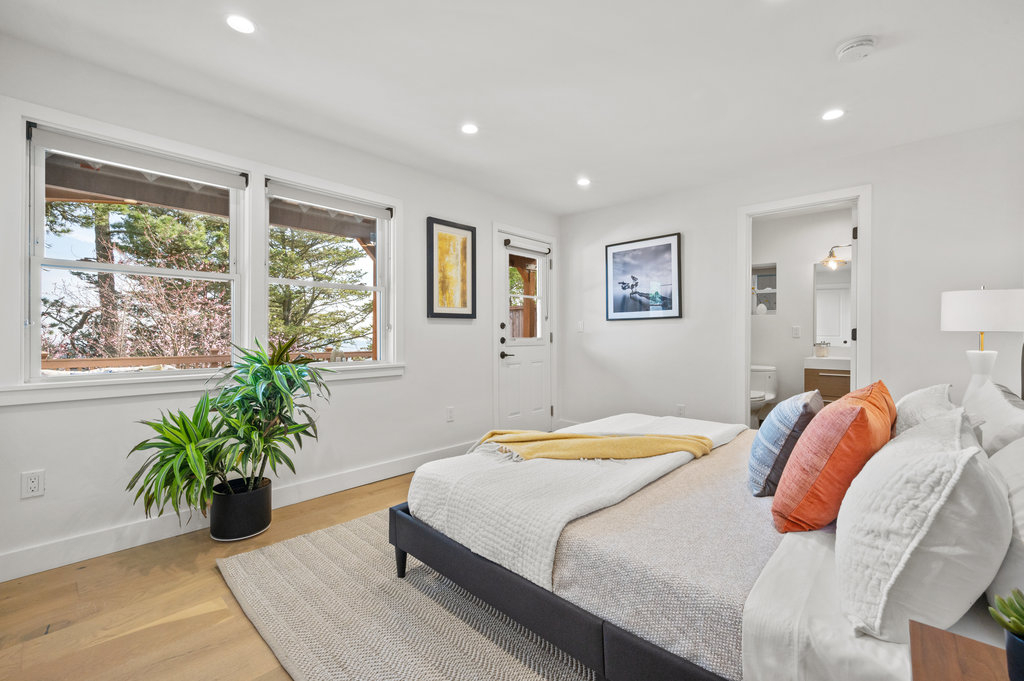 View of the primary bedroom with walkout deck access and ensuite