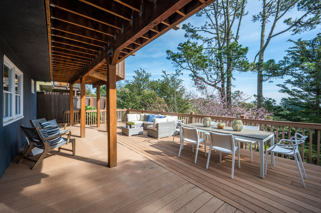 View of the lower walkout deck with outdoor dining and living areas