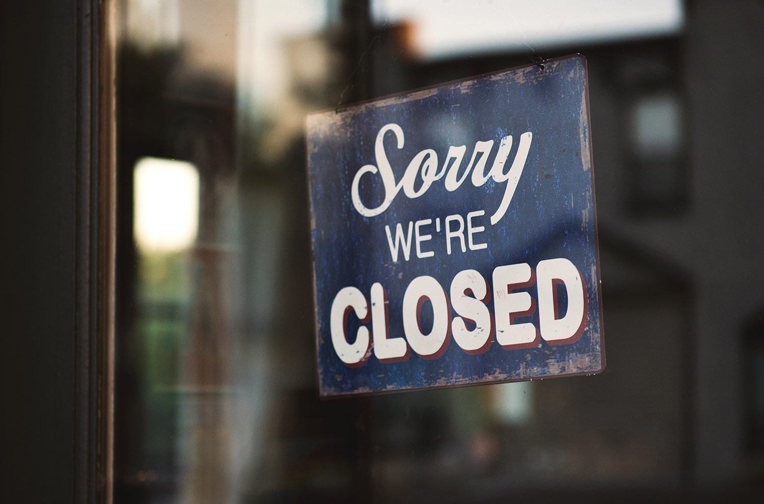 View of a 'we're closed' sign on a window