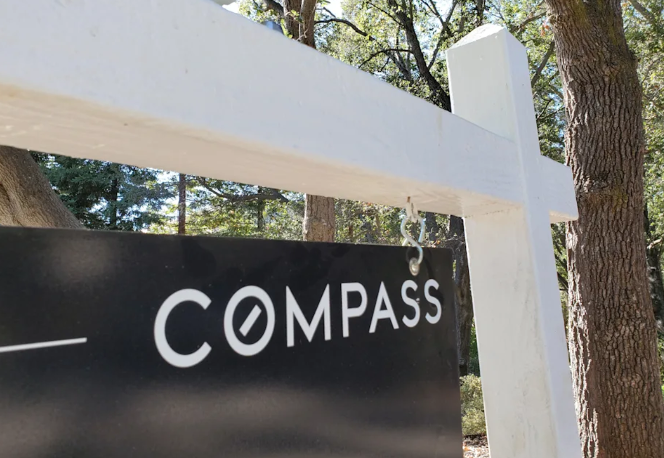 A for sale property sign showing the Compass logo