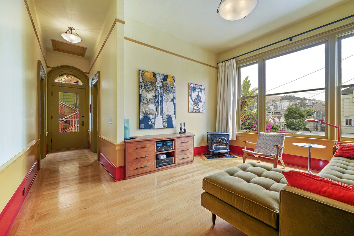 View of a living area, showing large windows and wood floors