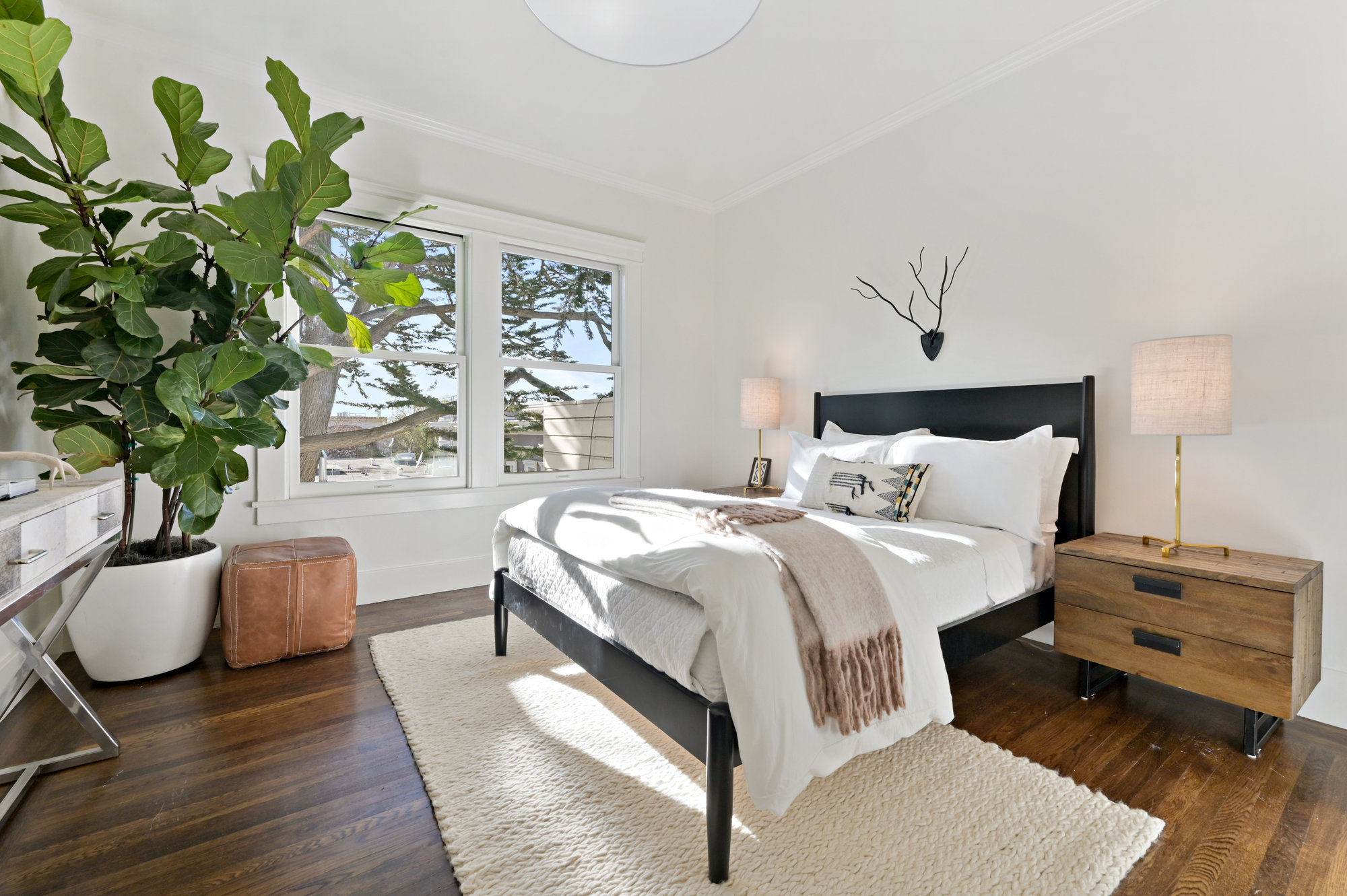 View of the third bedroom, showing a large room with wood floors and big windows