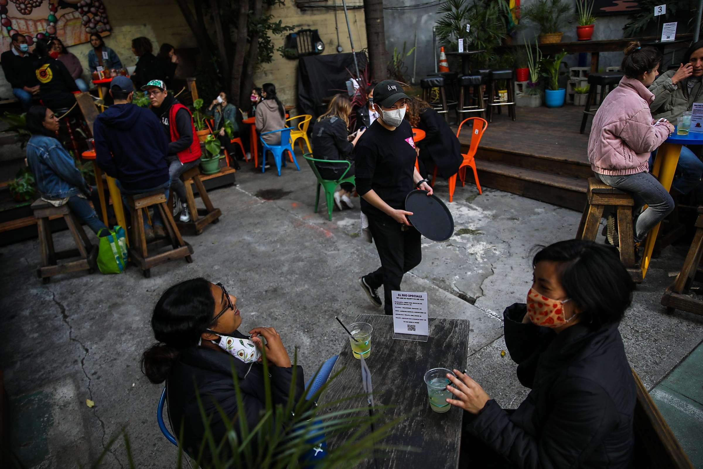 People wearing masks and sitting at tables