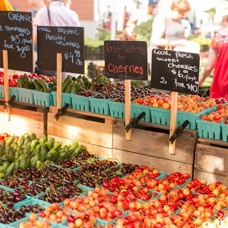 Produce in containers with labels at a farmers market