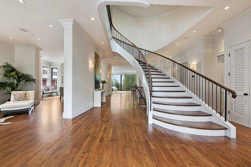 Property Photo: Large entry area with wood floors and grand staircase 