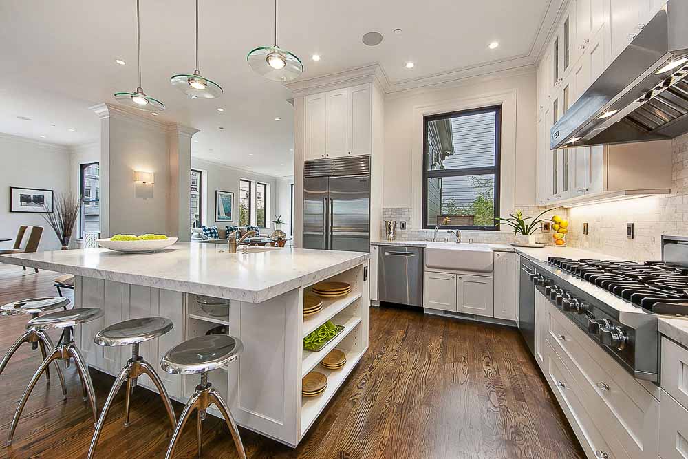 Property Photo: Kitchen with wood floors and white cabinets