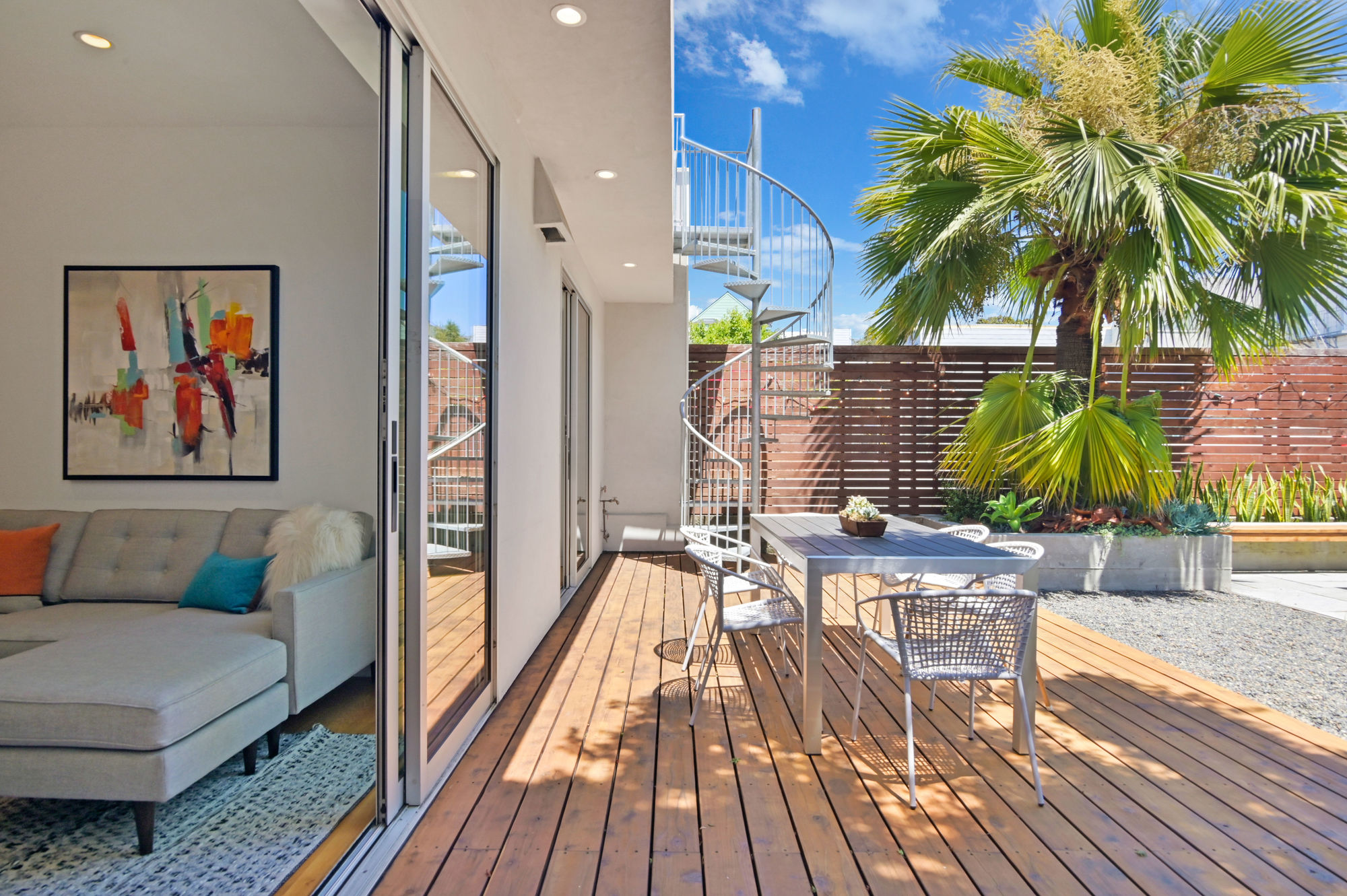 Property Photo: Partial view of the living room and out door patio with a spiral staircase leading to the second level deck