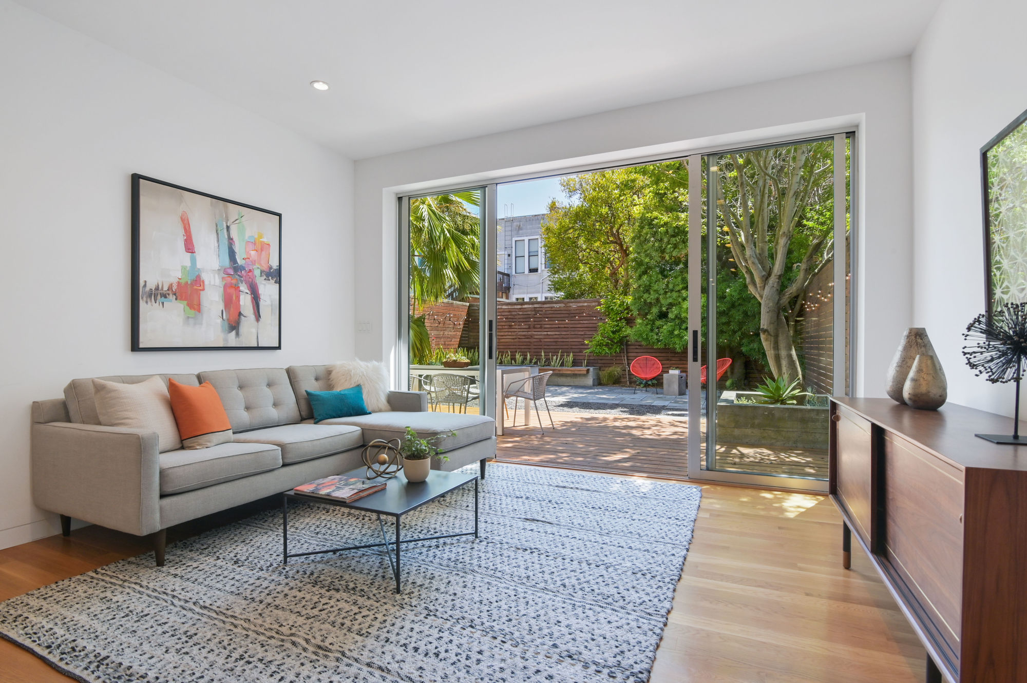 Property Photo: View of living room for the lower unit, featuring large open glass doors 