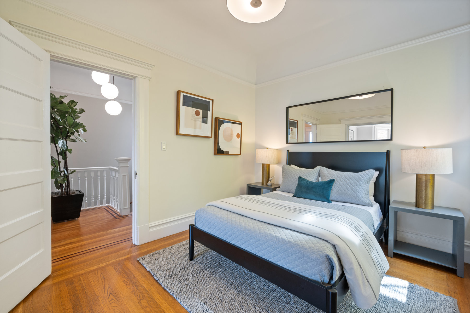 Property Photo: First bedroom in upper unit. Queen bed with bedside tables on each side of bed. Harwood floors. 