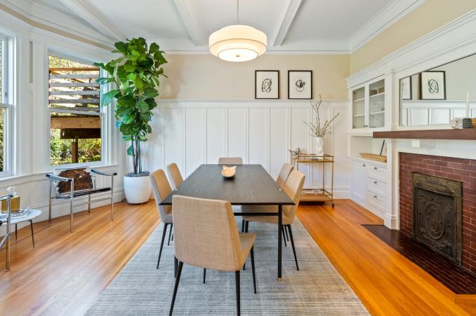 Property Thumbnail: Dining table is centered with bay windows to the left and fireplace to the right. 