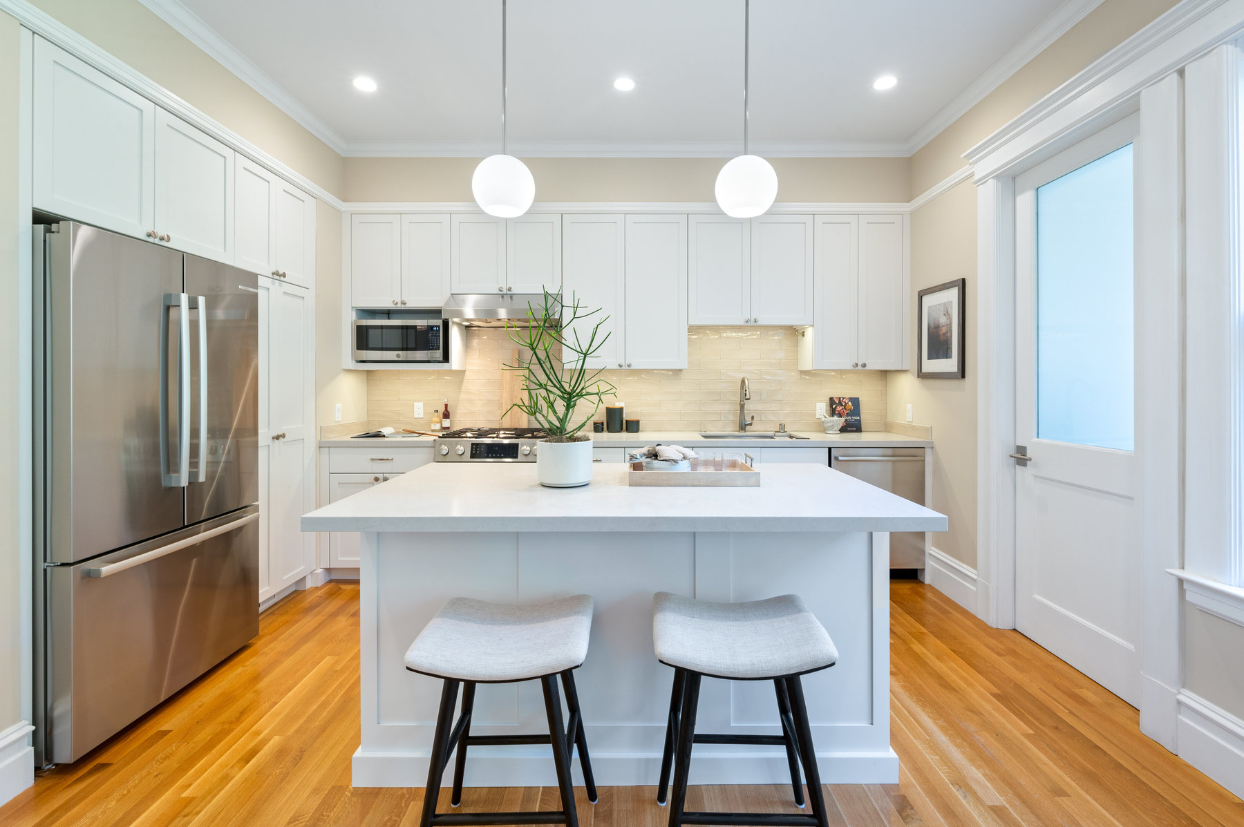 Property Photo: Kitchen has island with two stools. 