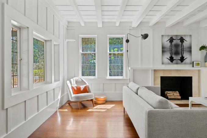 Property Thumbnail: Looking into living room from the entryway. Small chair near windows. 