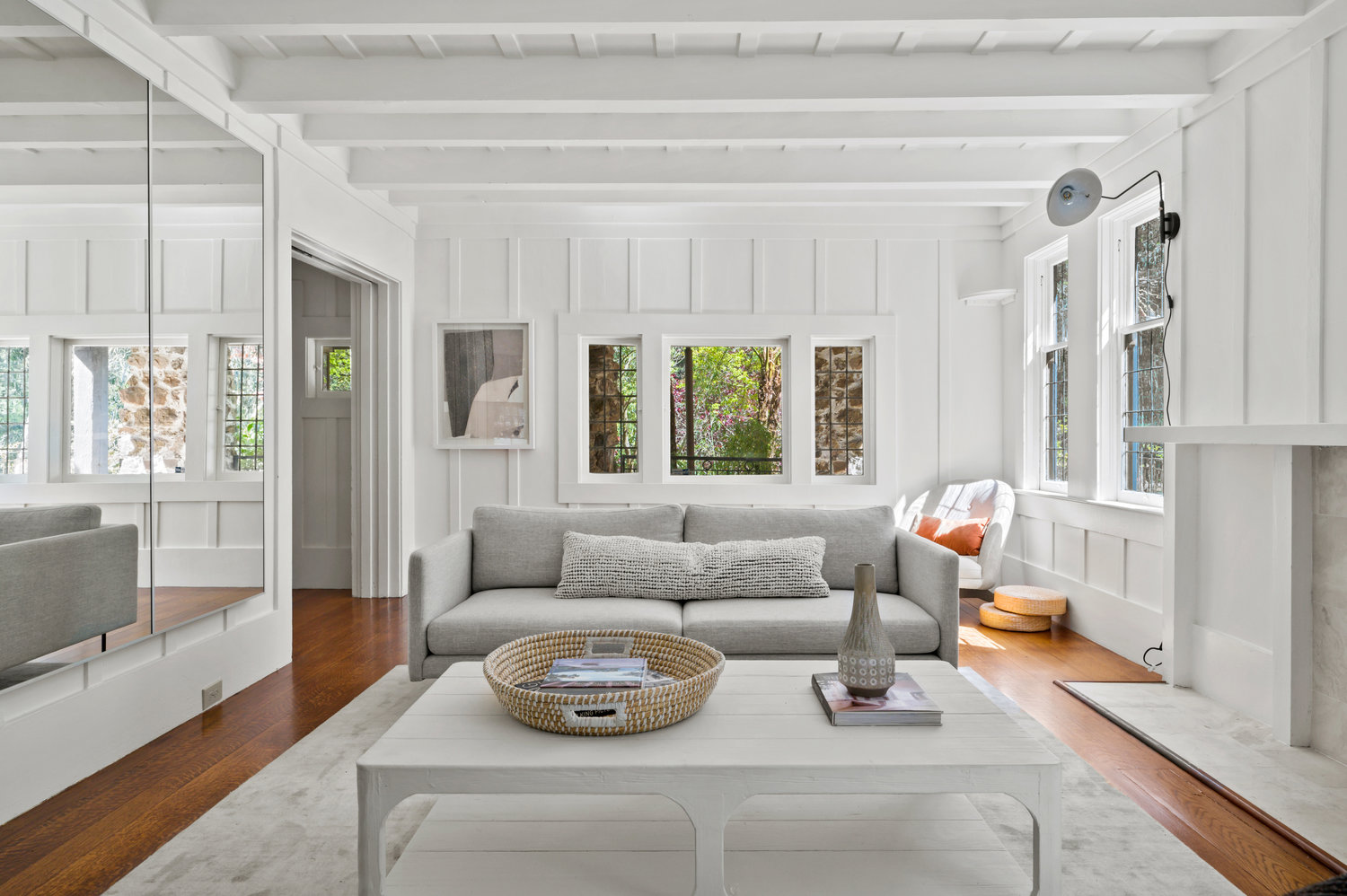 Property Photo: Living room that features stunning wood detailing, lots of windows that let in lots of natural light. Hard wood floors through out. 