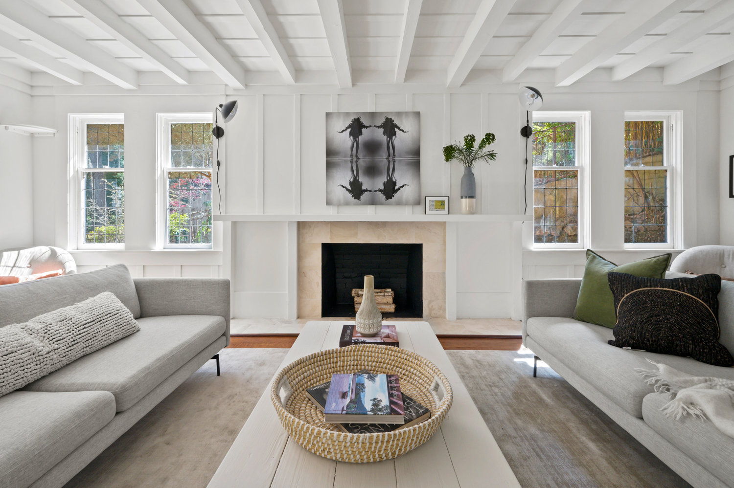 Property Photo: Living room has large fireplace with wood mantel. Two couches and large coffee table in the middle. 