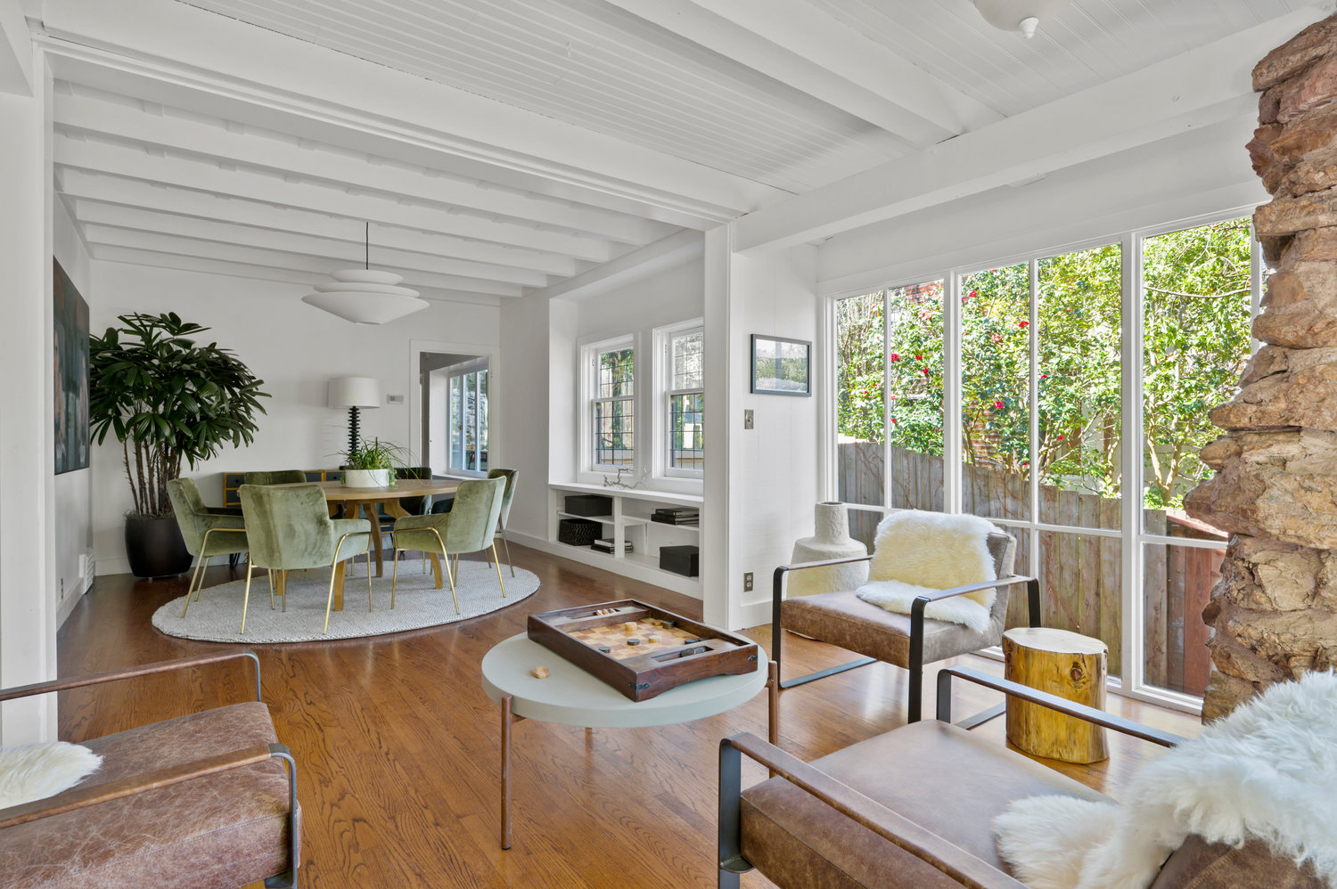 Property Photo: Sitting area looking over to dining area. Walls and ceiling are white with lots of wood detailing. 