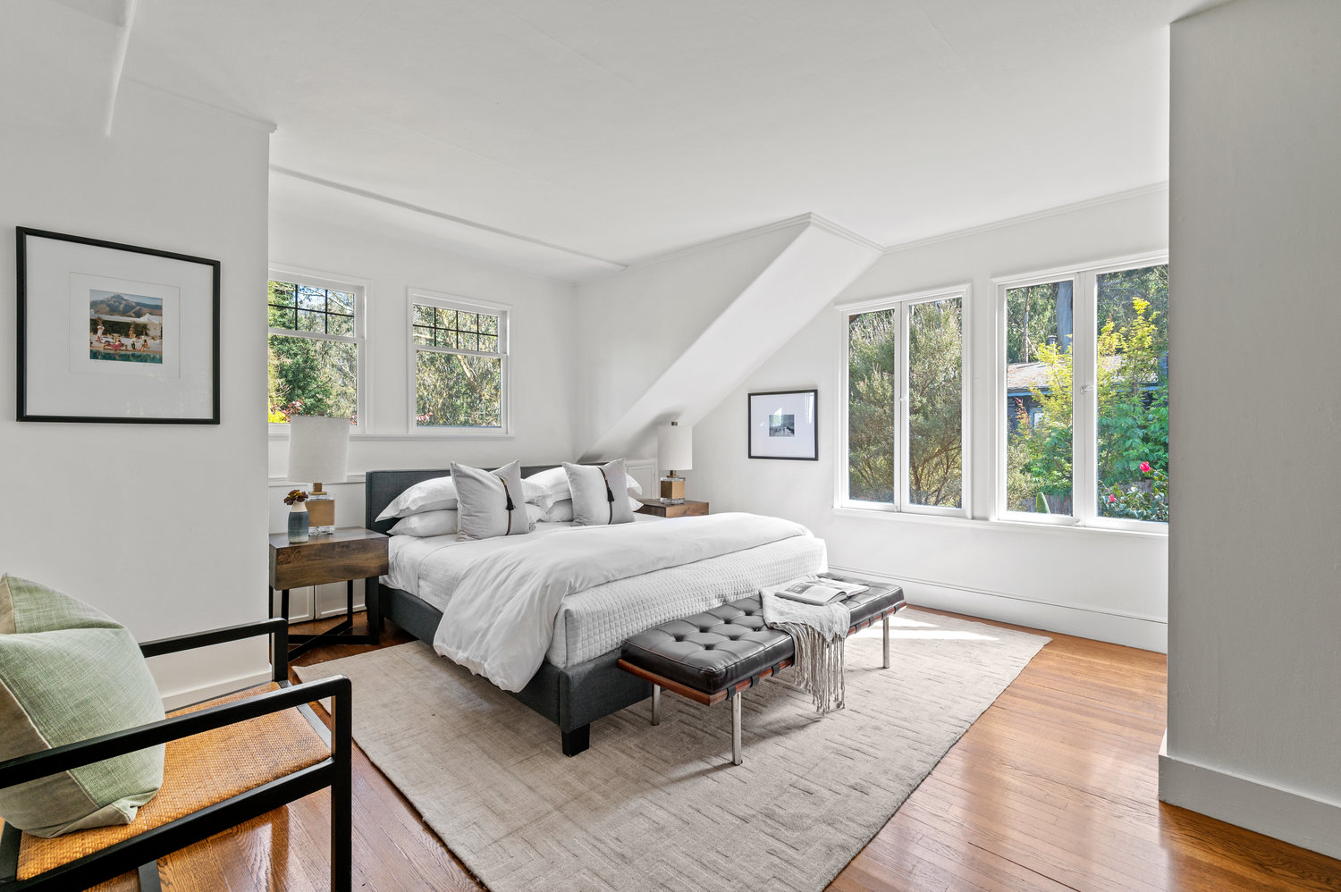 Property Photo: This bedroom has windows behind and on the right side of bed. Hardwood floors through out. 