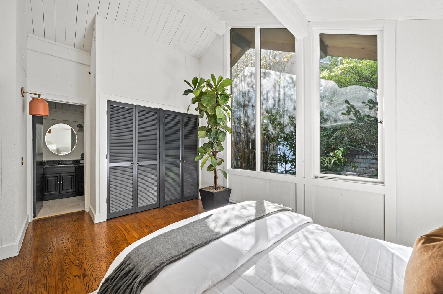 Property Photo: Primary bedroom has a king bed, large windows and on suite bath.