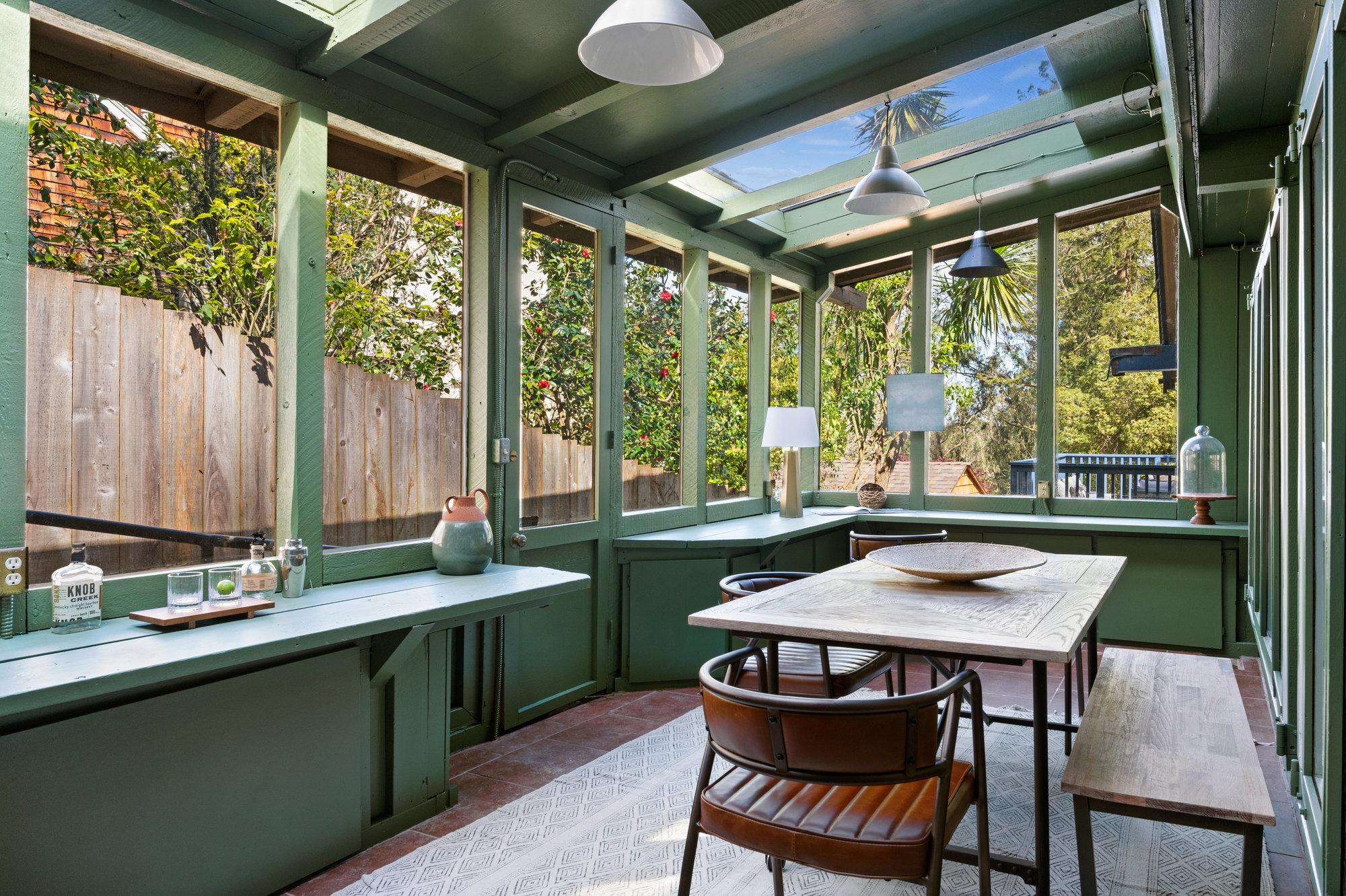 Property Photo: Green room off the kitchen that it staged with dining table, bench and chairs. Lots of storage and glass windows all around and skylights. 