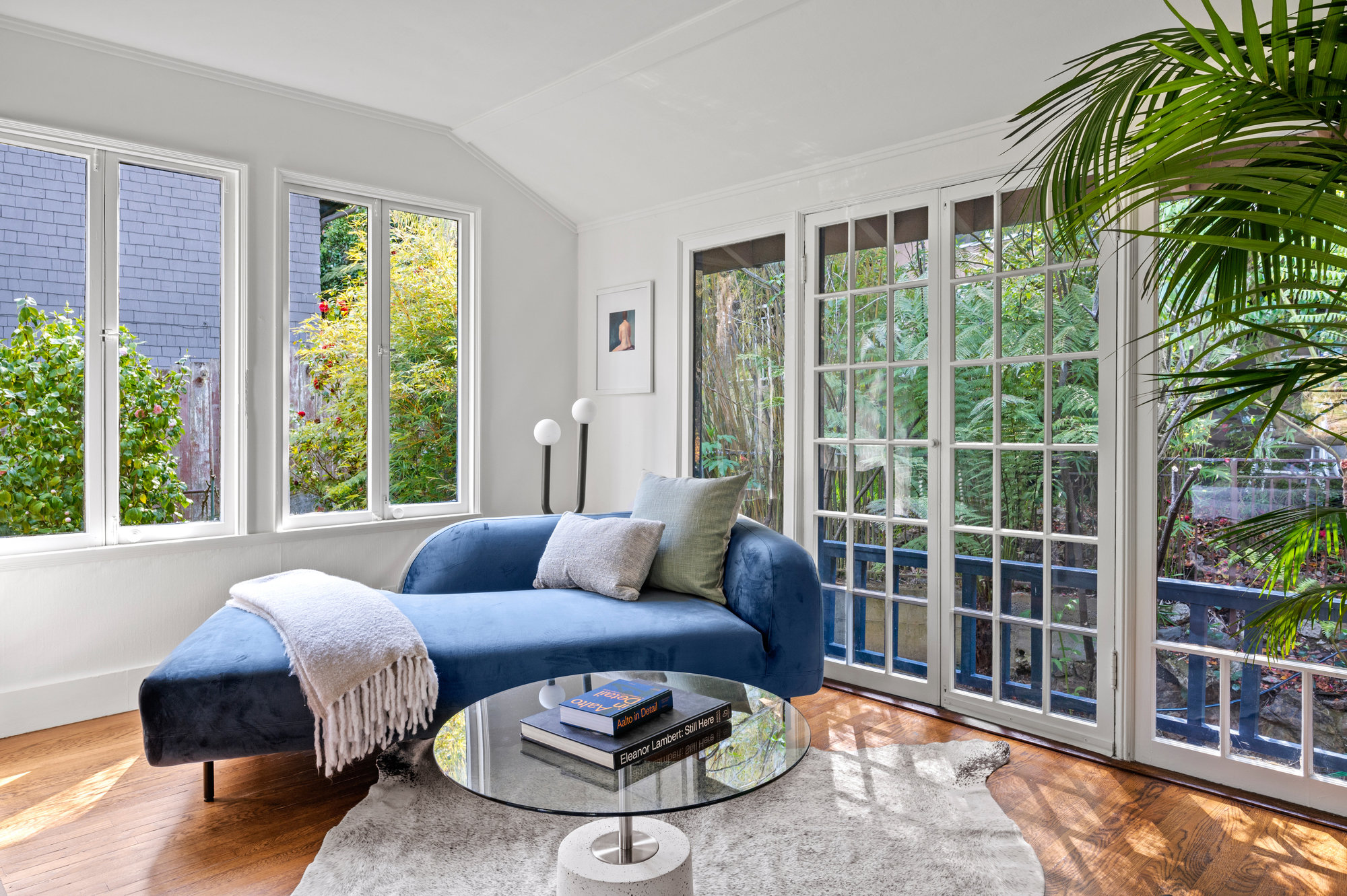 Property Photo: Sitting area in bedroom has chaise small glass table. There also are french doors that open up to the back yard area. 