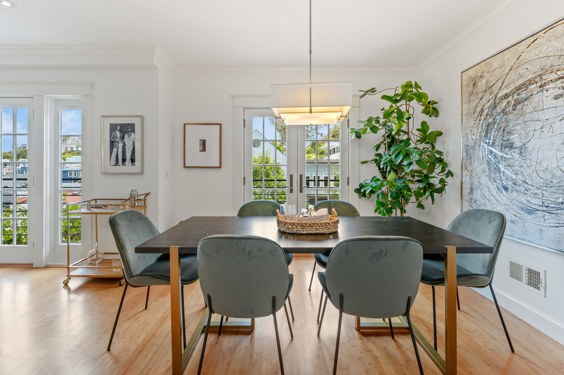 Property Photo: Photo of dining room with dining table centered and french doors looking out to Cole Street as backdrop. 