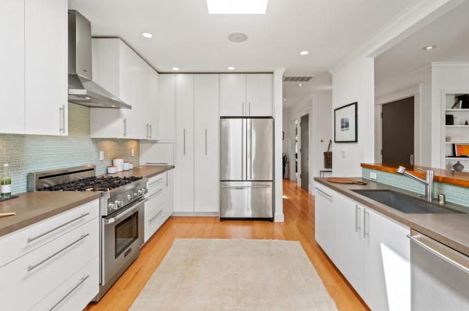 Property Thumbnail: Kitchen from dining room. All stainless steel appliances with all white cabinetry. 