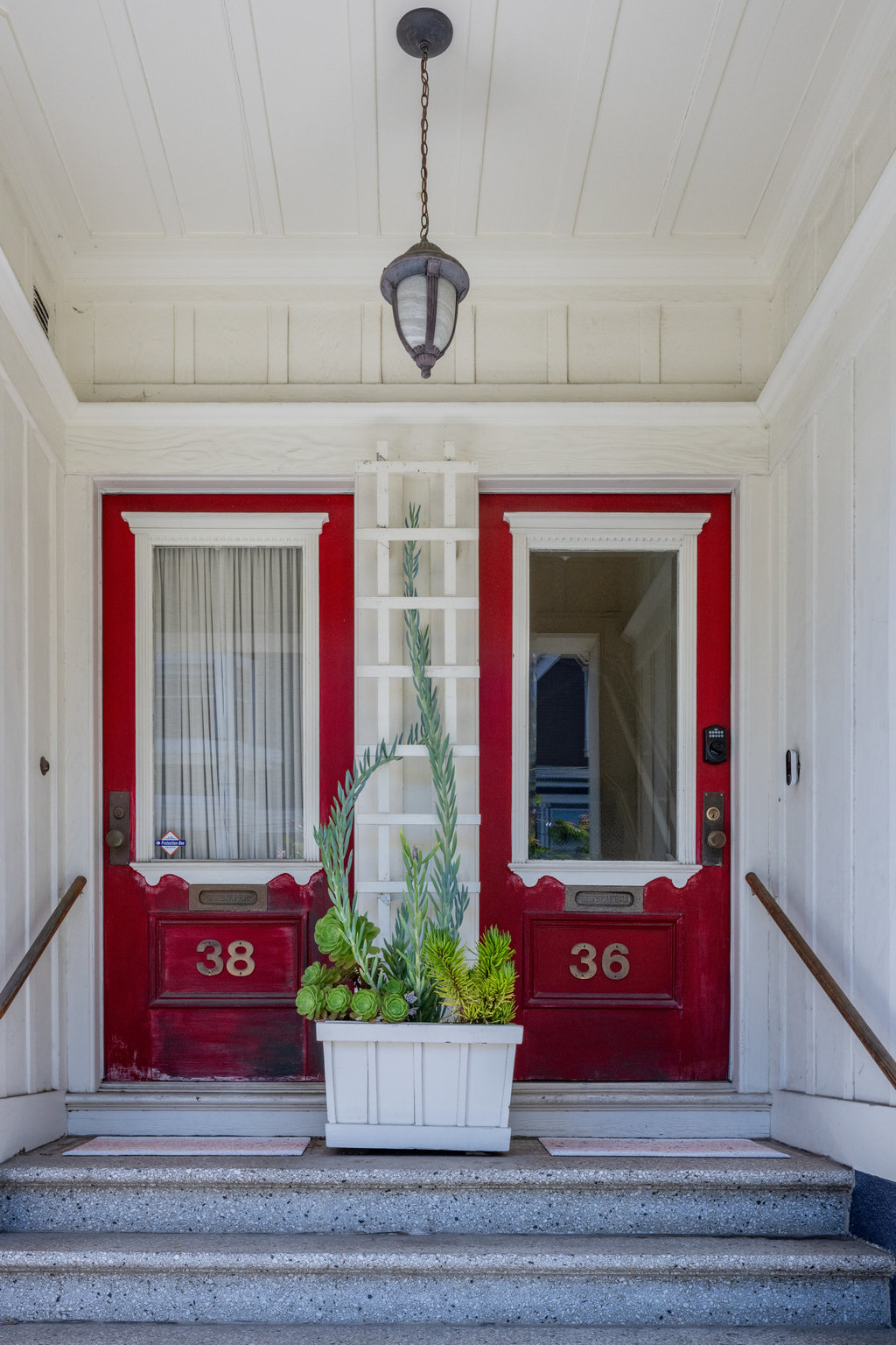 Property Photo: Front entryway. There is a small staircase that leads up to the doorway. There is red door. 