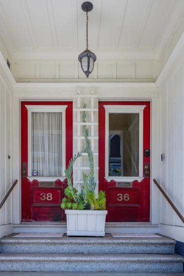 Property Thumbnail: Front entryway. There is a small staircase that leads up to the doorway. There is red door. 
