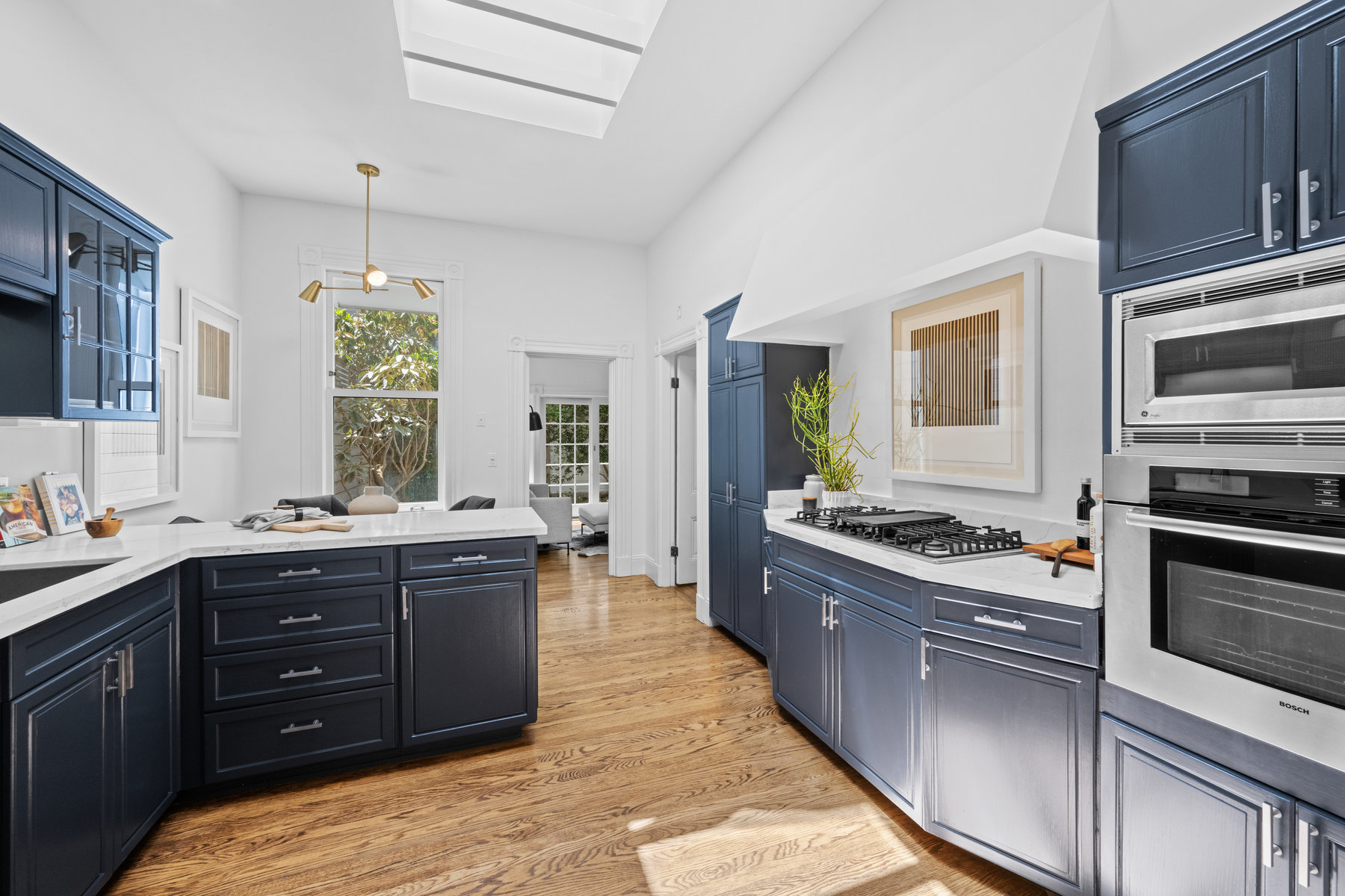 Property Photo: Kitchen has blue cabinets with white stone countertops. There is a skylight that makes room nice and bright, 