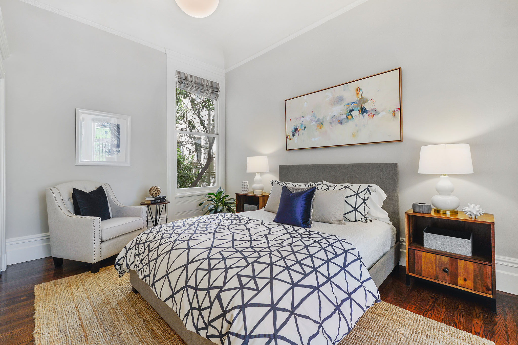 Property Photo: Bedroom with wood floors and a window