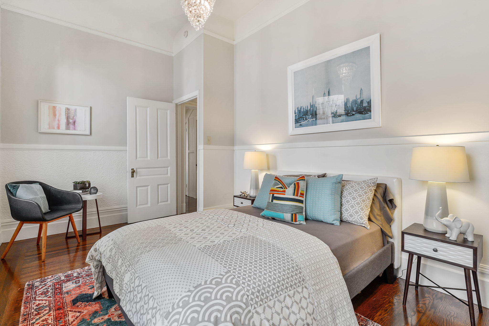 Property Photo: Another bedroom with wood floors and white chair-rail 