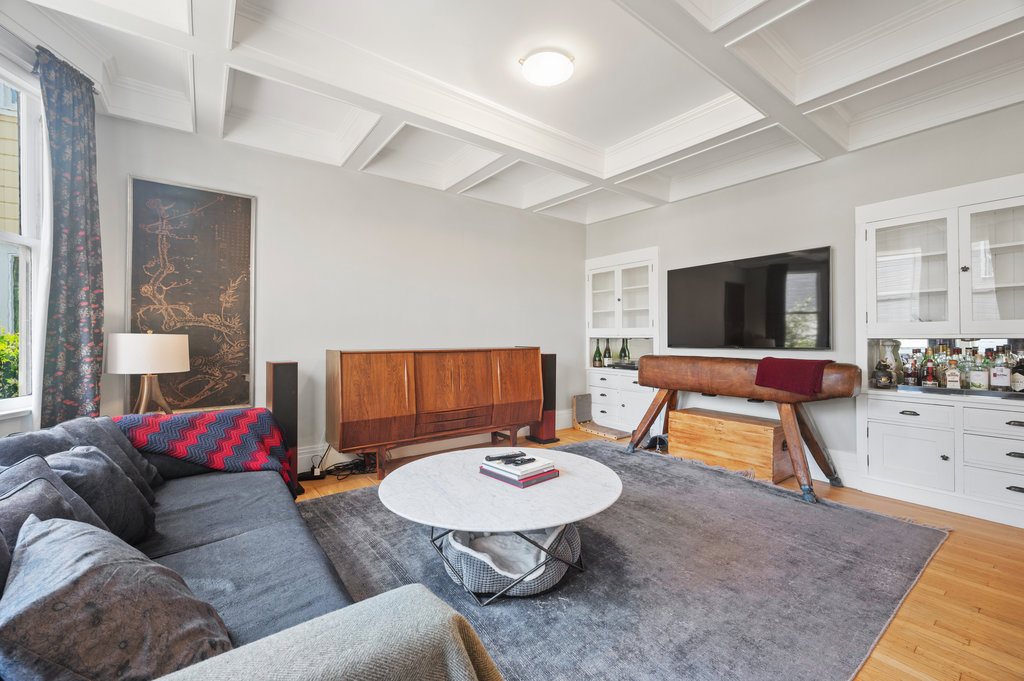 Property Photo: Living Room has beam detailing, built-ins and wood flooring. 