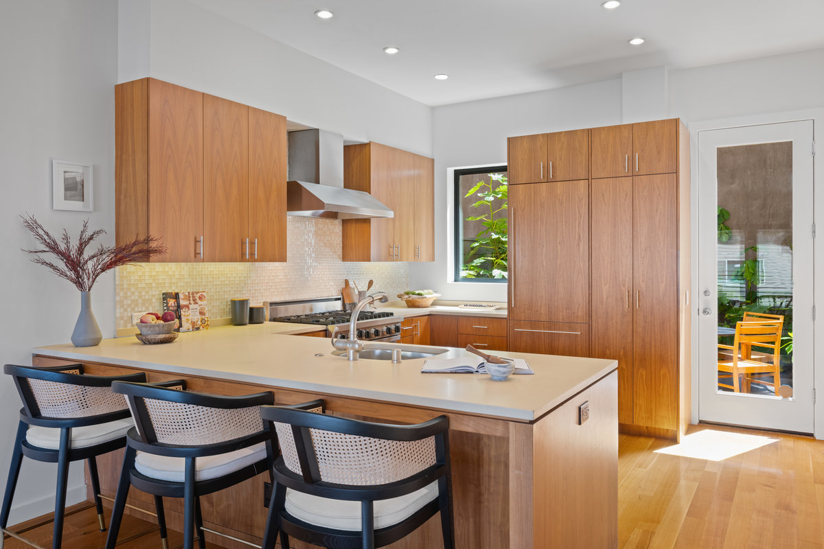 Property Photo: Kitchen has oversized counter that has seating for 3 with sink on other side. Windows look out to back patio letting in lots of natural light. 