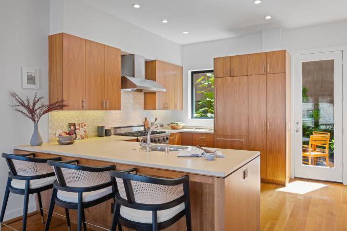 Property Thumbnail: Kitchen has oversized counter that has seating for 3 with sink on other side. Windows look out to back patio letting in lots of natural light. 