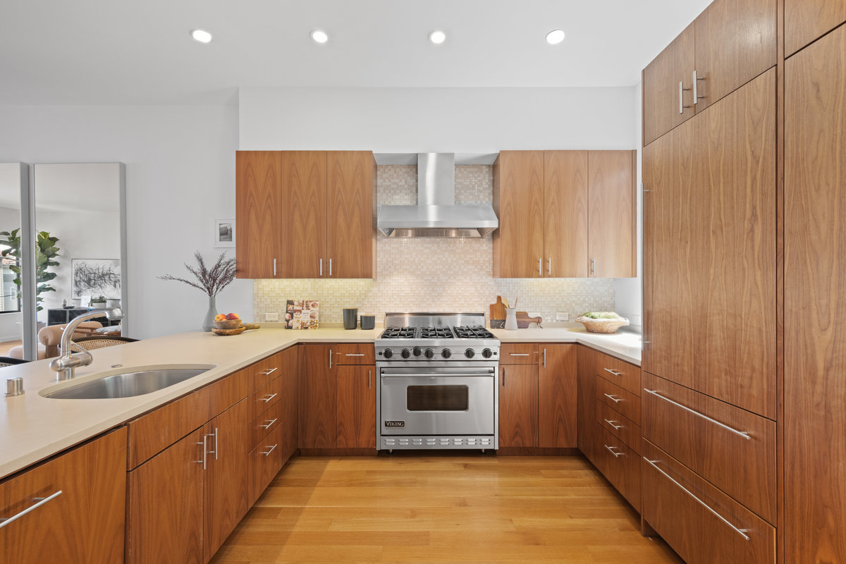 Property Photo: Kitchen has light colored countertops with light wooden cabinetry. 