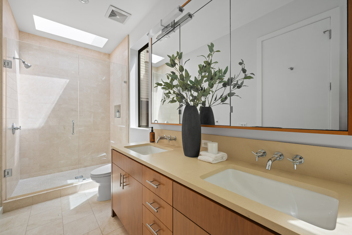 Property Photo: Primary onsuit bathroom has large walk in shower and double vanity. There is a skylight above shower that lets in lots of natural light. 