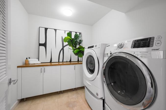 Property Thumbnail: Laundry room has built in lower cabinets with wooden countertop and large side by side washer and dryer.