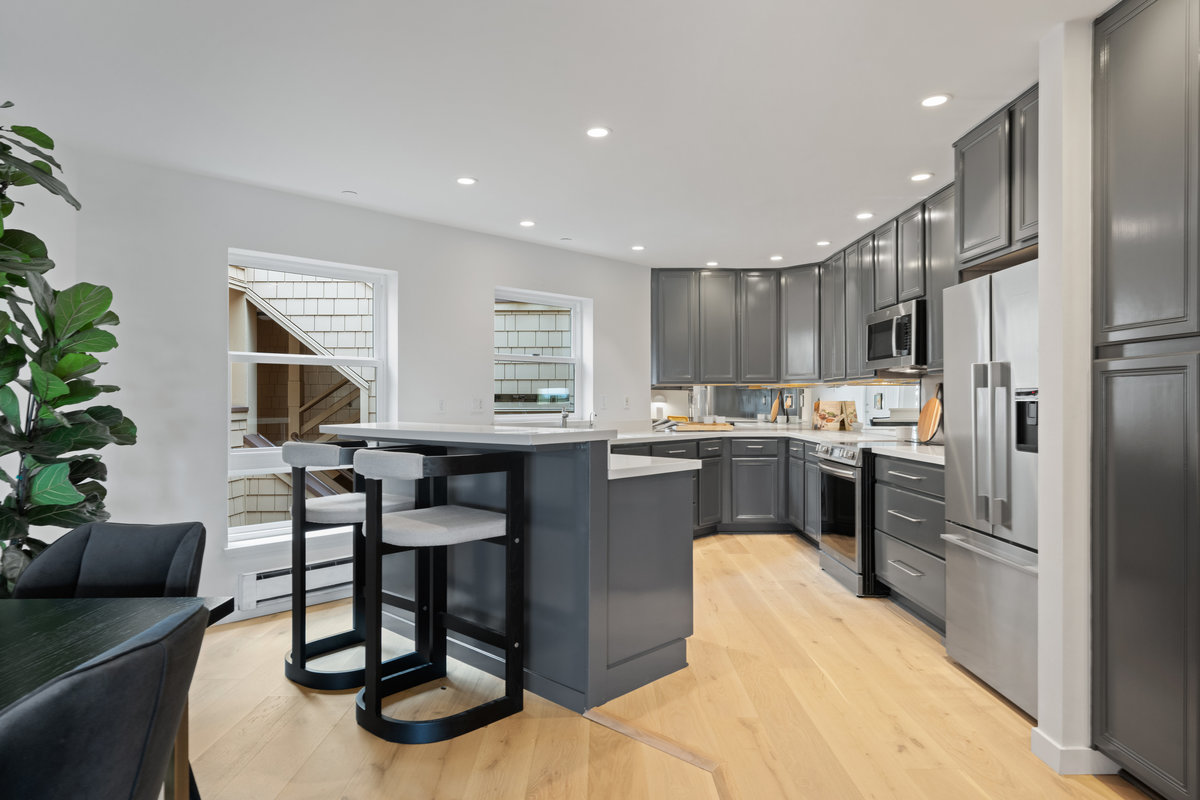 Property Photo: There kitchen has a small breakfast bar and two large windows that look out to the courtyard of the building. 