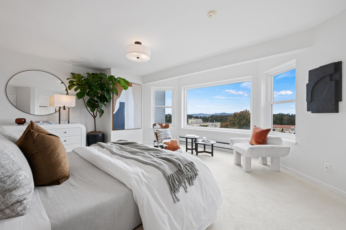 Property Photo: Primary bedroom has large bay windows that has beautiful views. There is a sitting area in front of the windows. 