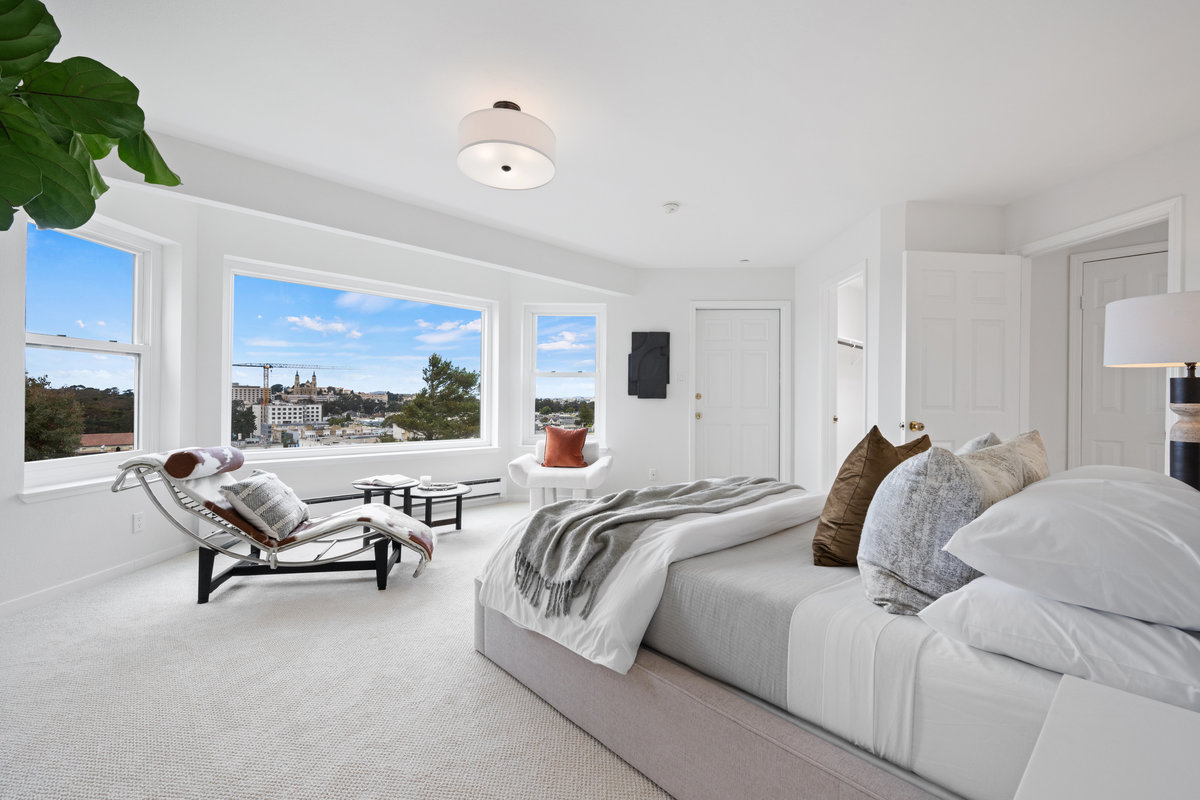 Property Photo: The sitting area in front of the large bay window has chaise, small table and another plush chair. 