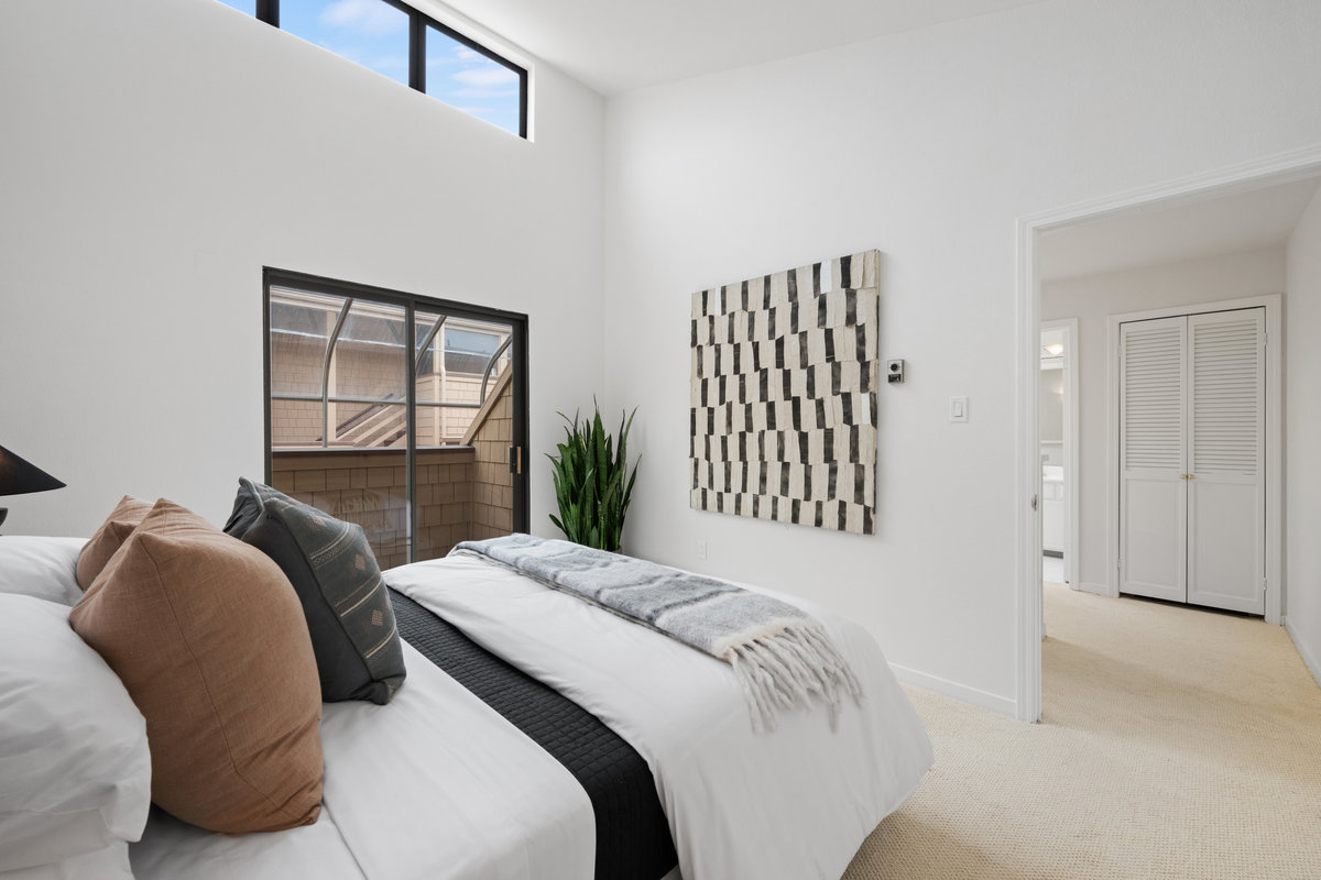 Property Photo: Guest bedroom also has windows above glass doors that let in lots of natural light. There ceilings are high. 