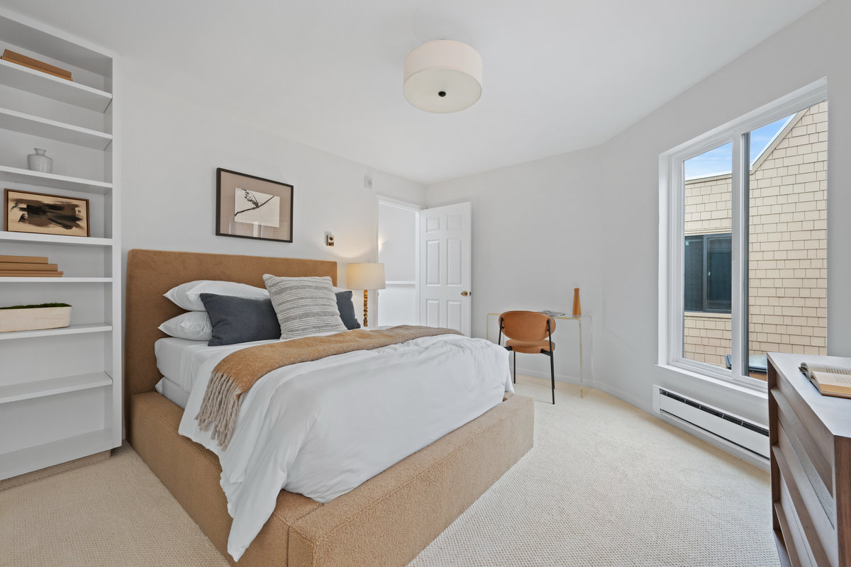 Property Photo: The 3rd bedroom has built in bookshelf and is staged with a queen bed. 