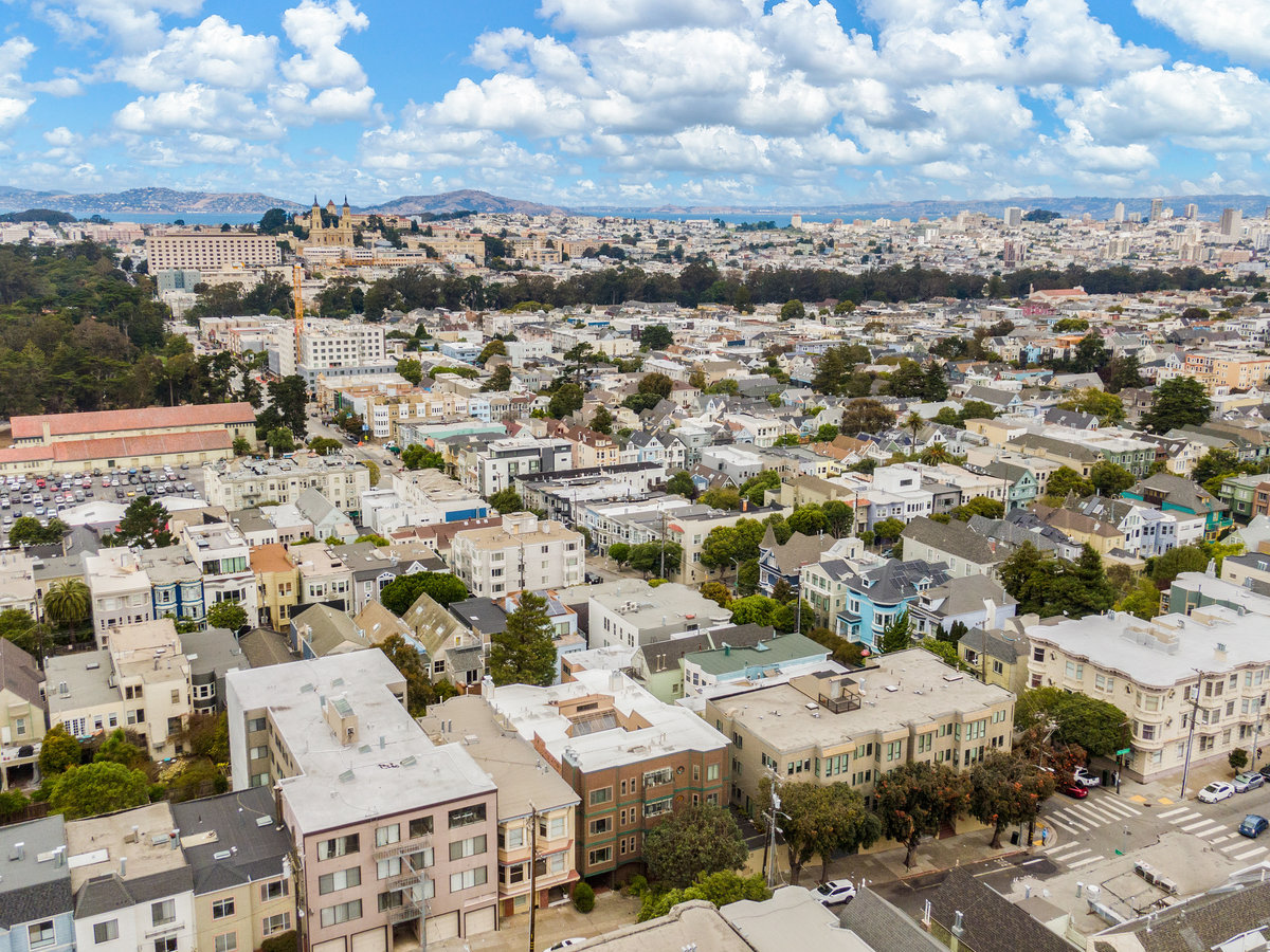 Property Photo: Aerial photo of neighborhood all the way downtown. Lots of pretty puffy white clouds in the sky. 