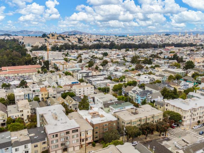 Property Thumbnail: Aerial photo of neighborhood all the way downtown. Lots of pretty puffy white clouds in the sky. 