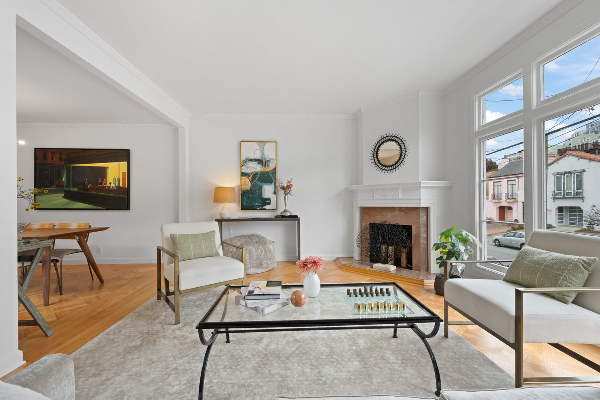 Property Photo: Looking over to fireplace in living room. It surrounded by tile with wooden mantel. 