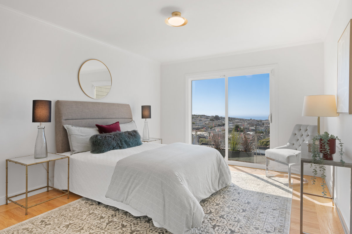 Property Photo: The second bedroom on the upper level has sliding glass doors that open up to small juliet balcony. There is a queen bed and hardwood floors. 