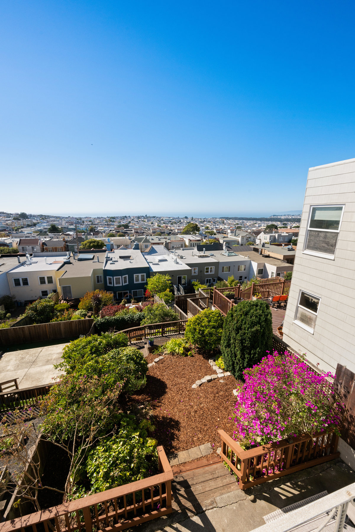 Property Photo: Looking over the beautifully landscaped yard from the back deck. You can also see the ocean. 