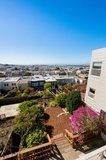 Property Thumbnail: Looking over the beautifully landscaped yard from the back deck. You can also see the ocean. 