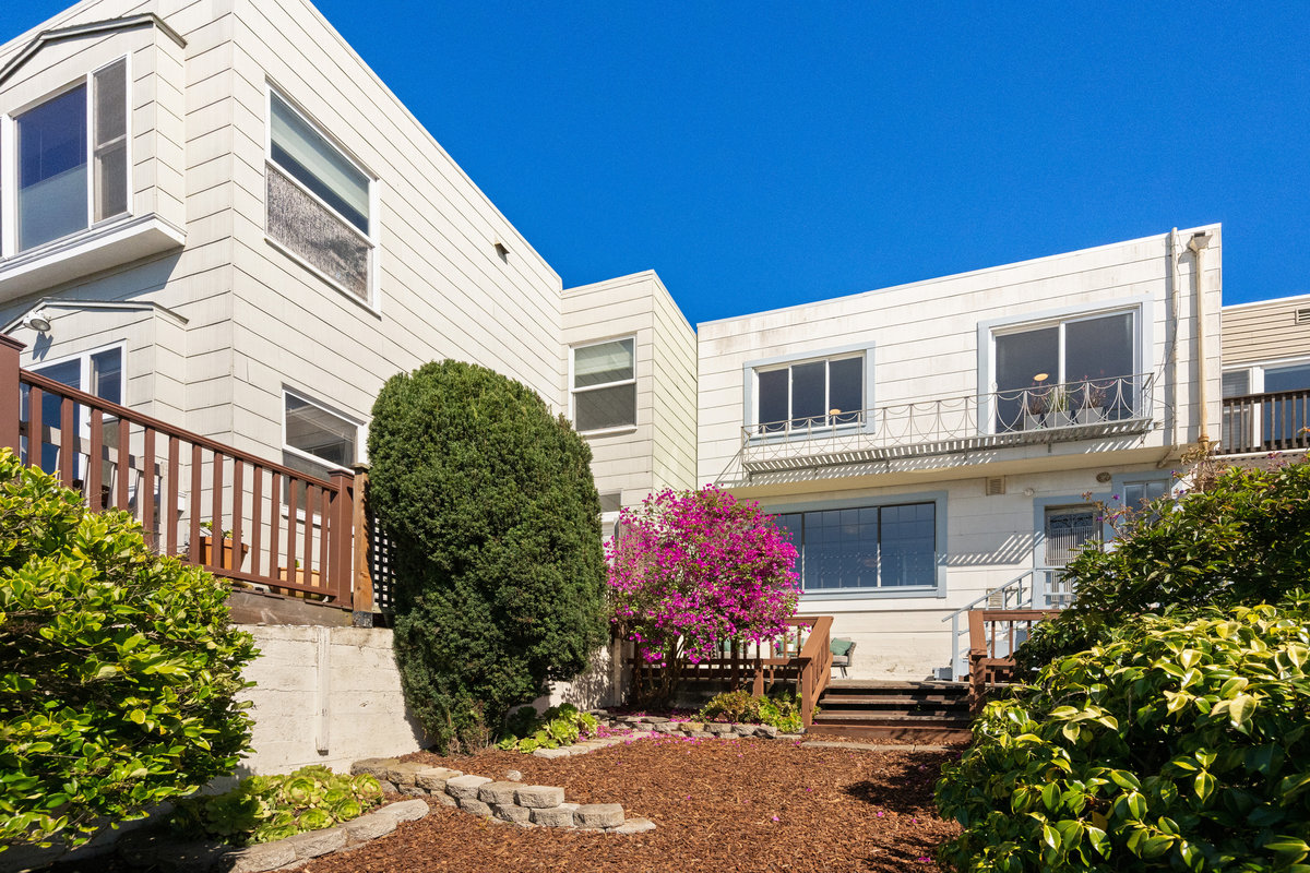 Property Photo: Looking to the back exterior of hone from one of the tiers of the yard. 